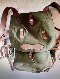 "These Vintage never issued / never used Romanian Military  Backpacks are made of thick canvas and even thicker leather put together with  heavy machine stitching and metal rivets. Bags are in unused Mint condition. They Are Roughly  40 Liters. INSIDE OF MAIN PACK: Cord Closure   Dimensions from seam to seam roughly measure 11 3/4\" To 13 3/4\" x 15 5/8\" x 10 1/4\"  these packs are wider on the bottom than on the top. The main pack space is covered by a large flap with buckle closure . EXTERNAL OF BACKPACK FEATURES: The main cover / flap  has leather attachment points I am assuming it was used  for a mess kit. On the sides you'll find additional  attachment points for a bed roll etc. and on the other side of pack  there is a  pouch for Rations or a Canteen etc.. Pack does not come with he Vintage Canvas Backpack For Outdoor Activities, Vintage Khaki Backpack For Everyday Use, Vintage Khaki Bag For Adventure, Vintage Canvas Backpack With Waxed Finish, Vintage Canvas Backpack For Outdoors, Vintage Backpack With Canvas Lining, Vintage Waxed Finish Backpack, Vintage Leather Backpack For Outdoor With Leather Handles, Vintage Waxed Canvas Backpack For Adventure