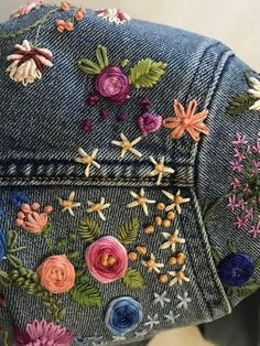 an embroidered denim jacket with flowers on it