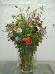 a vase filled with lots of different colored flowers