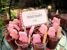 a table topped with lots of cups filled with ice cream and marshmallows