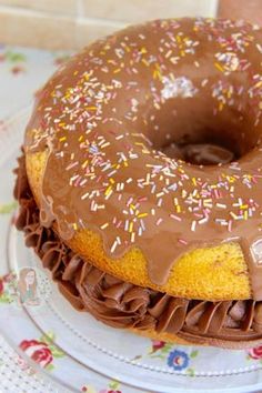 a chocolate frosted donut with sprinkles on a plate