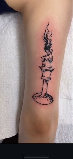 a tattoo on the arm of a woman with a candle and water fountain in it