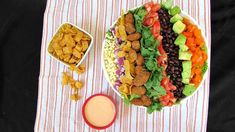 a plate with salad, beans, lettuce, carrots and other foods on it