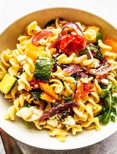 a white bowl filled with pasta and vegetables