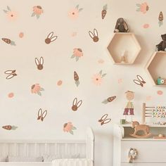 a baby's room decorated in pink and brown with flowers, bunnies and honeycombs on the wall