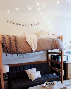 a bunk bed sitting next to a couch in a room with lights on the wall