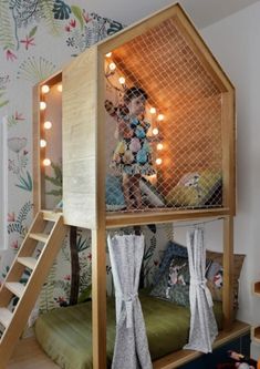 a child's bedroom with a loft bed and stairs to the second floor, decorated in floral wallpaper