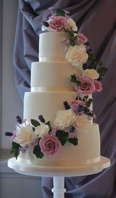 a three tiered wedding cake with pink and white flowers