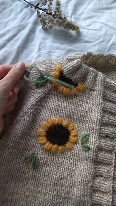 someone is knitting a sweater with sunflowers on it