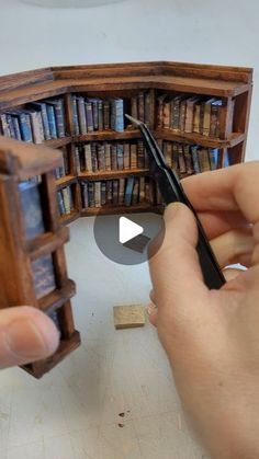 someone is making a miniature bookcase out of wood