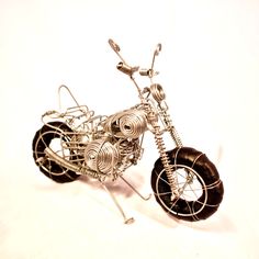 a wire sculpture of a motorcycle on a white background