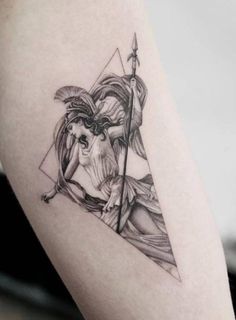 a black and white photo of a woman with an arrow tattoo on her thigh,