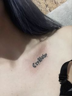 a woman with a tattoo on her chest that reads, cripblaar in cursive writing