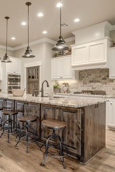 a large kitchen with an island and bar stools