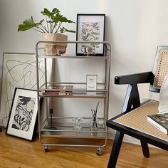 a metal shelf sitting on top of a hard wood floor next to a chair and table