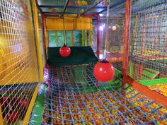 an indoor play area with balls and nets