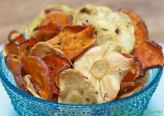 a blue bowl filled with potato chips on top of a table