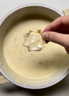 a person dipping some kind of sauce in a bowl