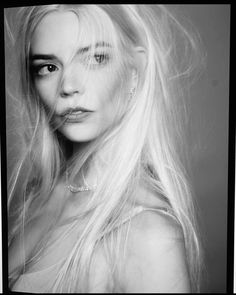 a black and white photo of a woman with long blonde hair, looking straight ahead