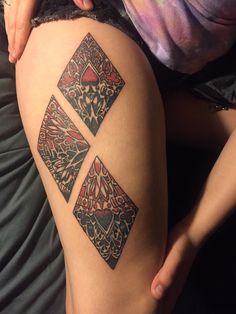 a woman's thigh with tattoos on it and an image of three squares in the middle