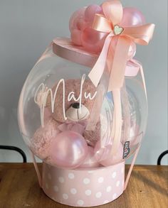 a pink teddy bear in a bubble filled gift box with the word mau on it