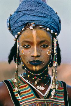 an african woman with painted face and headdress