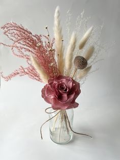 a vase filled with flowers and dry grass