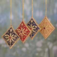 three ornaments hanging from chains in the shape of square and rectangles with floral designs on them