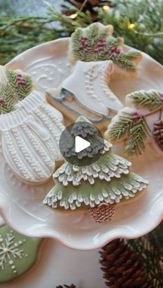 decorated christmas cookies on a plate with pine cones