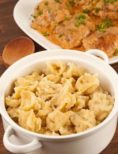 two white dishes filled with macaroni and cheese