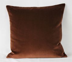 a brown pillow is sitting on a white surface and it's not very soft