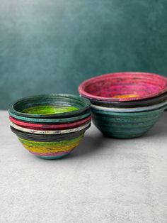 three colorful bowls sitting on top of a table