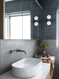 a white sink sitting under a mirror in a bathroom