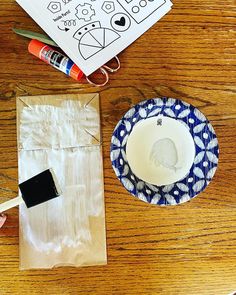 paper, scissors and other crafting supplies on a wooden table with an empty bag