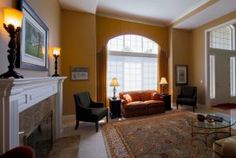 a living room filled with furniture and a fire place in front of a large window