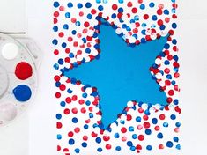 a blue star is surrounded by red, white and blue confetti on a sheet of paper