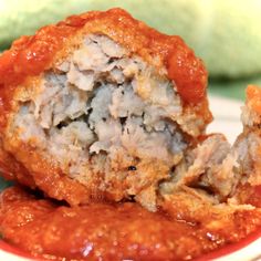 meatballs stuffed with marinara sauce on top of a white and red plate next to a green towel