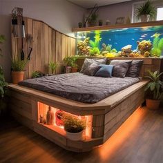 a bed with an aquarium in the middle and plants on either side, along with potted plants