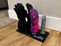 a pair of ski gloves sitting on top of a wooden floor