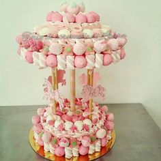 there is a cake made to look like a carousel with pink and white candies on it