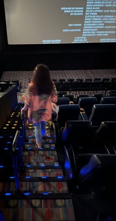 a woman walking up some stairs in an auditorium