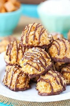 chocolate covered cookies on a white plate with bowls in the background