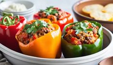 several stuffed peppers in a white bowl on a table