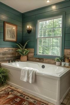 a bathroom with green walls and white bathtub next to a rug on the floor