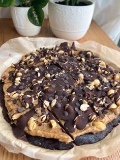 there is a chocolate pie with nuts on the top and one slice cut out to show it's filling