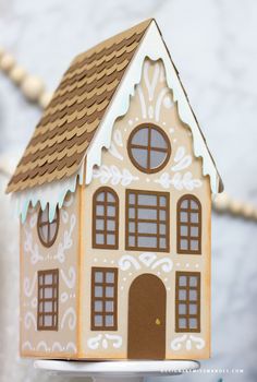 a paper house is on a cake plate