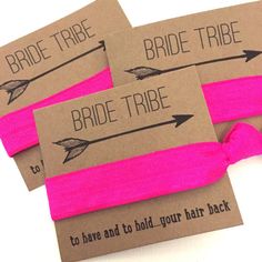 three pink hair ties tied to each other with the words bride tribe written on them