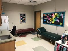 a room with a couch, chair and chalkboard on the wall next to a sink