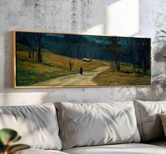 a painting hanging on the wall above a couch in a room with a white sofa