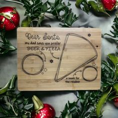 a cutting board with an image of a beer and pizza on it, surrounded by christmas ornaments